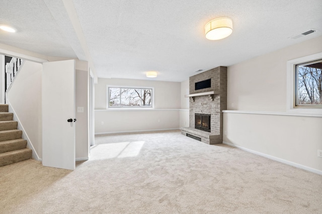 unfurnished living room featuring stairs, visible vents, carpet, and a fireplace