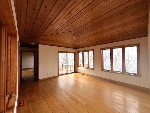 empty room featuring baseboards, lofted ceiling, wood ceiling, and light wood-style flooring