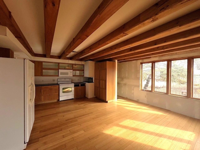 kitchen with beam ceiling, dark countertops, white appliances, and light wood-type flooring