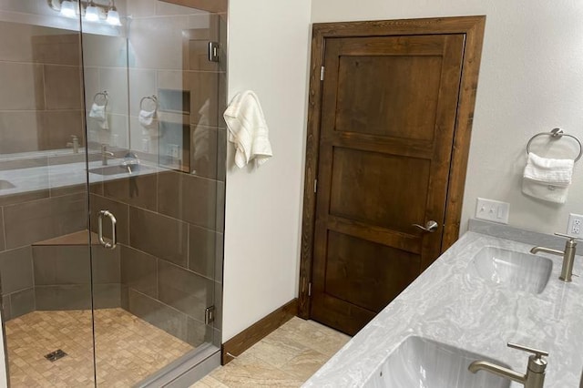 full bathroom with vanity, baseboards, and a stall shower