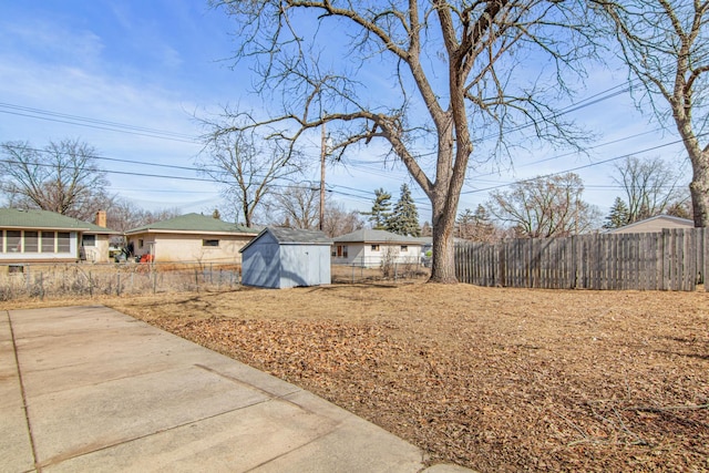 view of yard with a storage shed, an outdoor structure, and fence