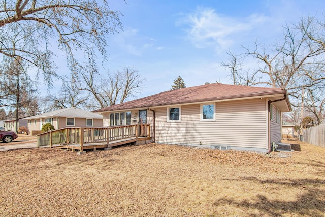 rear view of house featuring a deck and fence