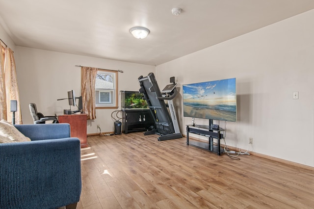 exercise room with baseboards and wood finished floors