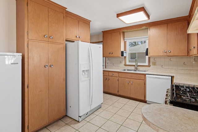 kitchen featuring a sink, white appliances, light tile patterned floors, and light countertops