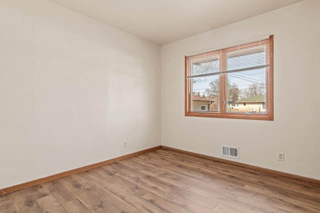 unfurnished room featuring light wood-style flooring, baseboards, and visible vents