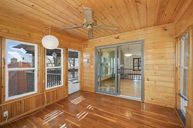 unfurnished sunroom featuring wood ceiling and a ceiling fan