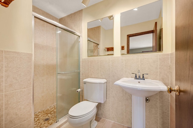 full bathroom with tile patterned floors, toilet, tile walls, and a shower stall