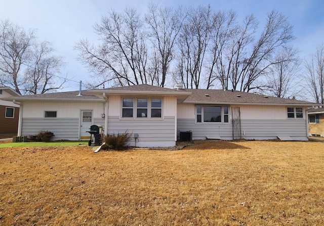 rear view of property featuring a lawn and central AC