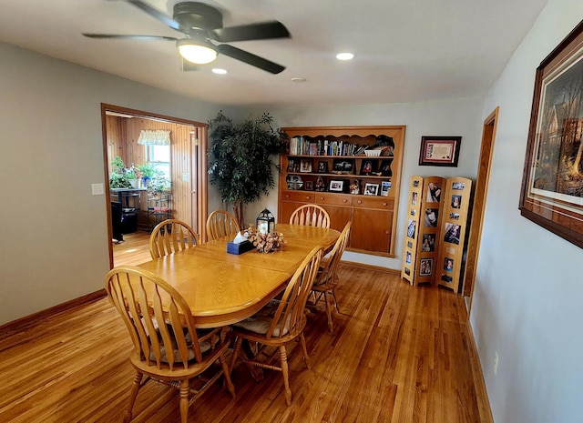 dining area featuring light wood-style flooring, baseboards, and ceiling fan