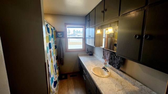 bathroom with vanity, wood finished floors, visible vents, baseboards, and curtained shower