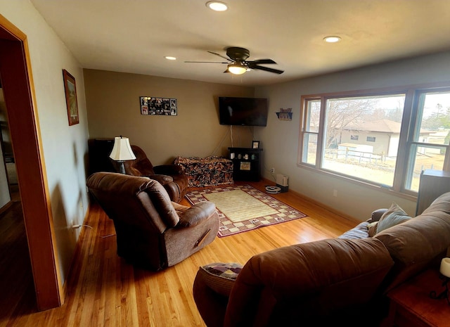 living room with wood finished floors, a ceiling fan, and recessed lighting