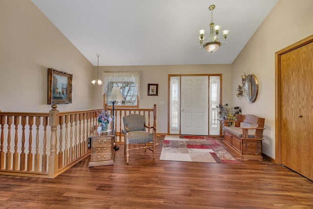 entrance foyer with vaulted ceiling, wood finished floors, baseboards, and a chandelier