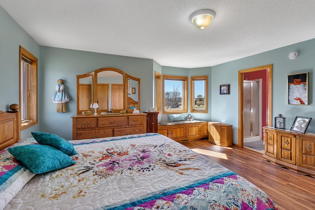 bedroom featuring a textured ceiling and wood finished floors