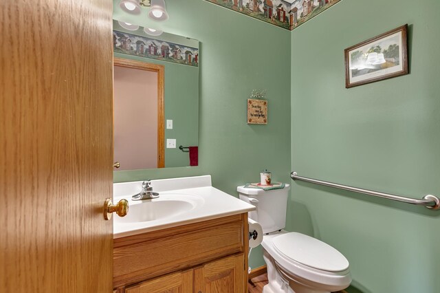 half bath featuring vanity and toilet