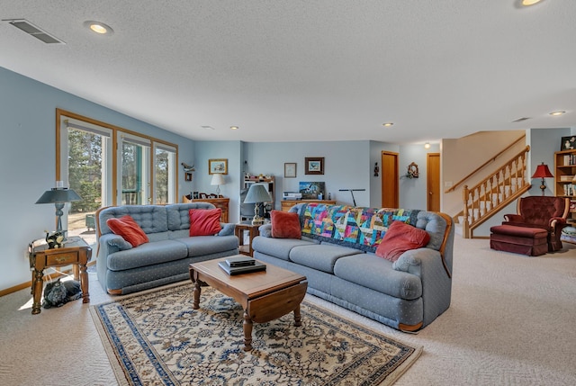 living room featuring visible vents, stairway, a textured ceiling, and carpet