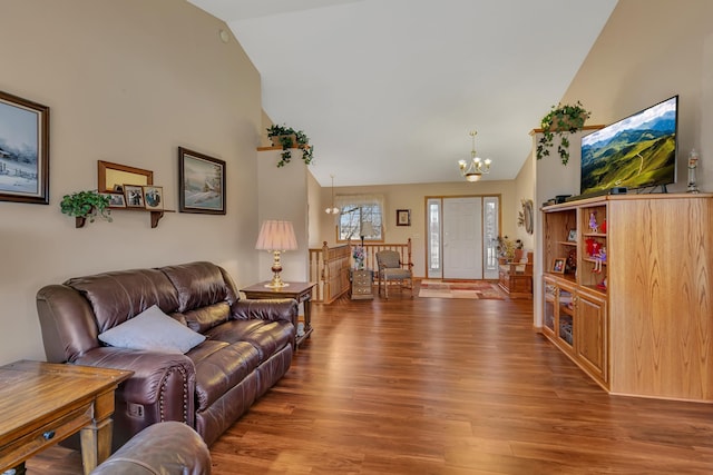 living room featuring high vaulted ceiling, wood finished floors, and a chandelier