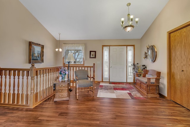 entryway with a chandelier, wood finished floors, baseboards, and vaulted ceiling