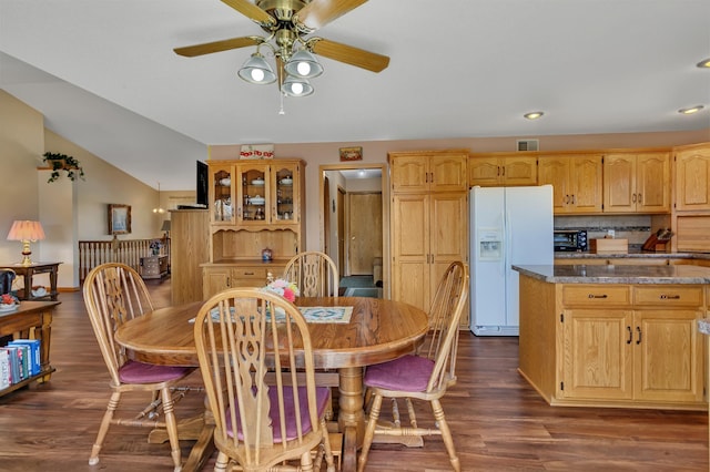 dining room with dark wood-type flooring, visible vents, a ceiling fan, and lofted ceiling
