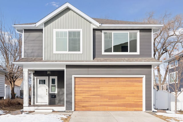 view of front of property featuring fence, roof with shingles, board and batten siding, concrete driveway, and an attached garage