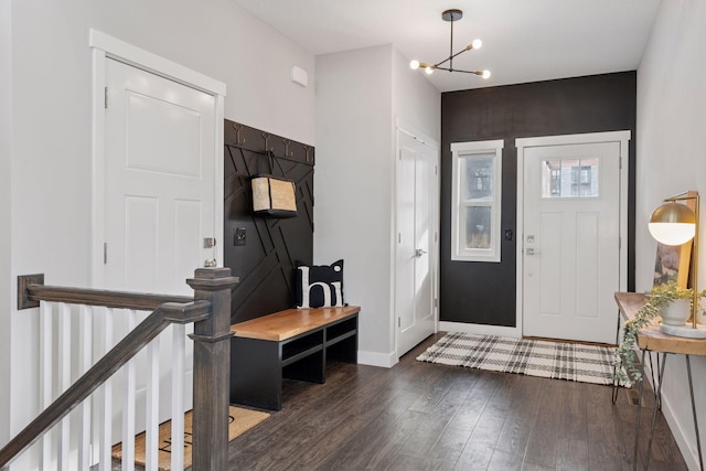 foyer featuring a chandelier, baseboards, and wood finished floors