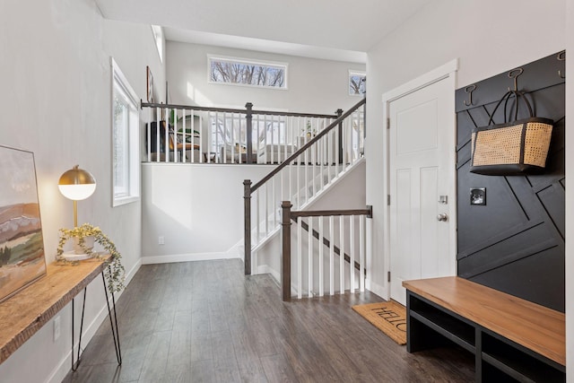 foyer with stairway, dark wood-type flooring, and baseboards