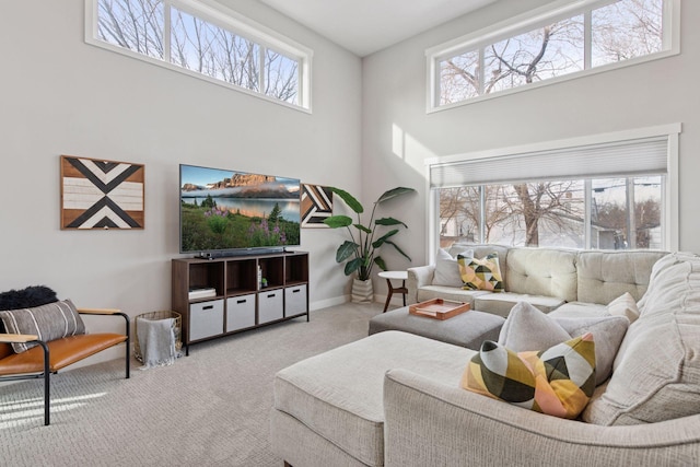 living room featuring baseboards, a towering ceiling, and carpet flooring