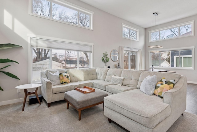 living room featuring baseboards and a towering ceiling