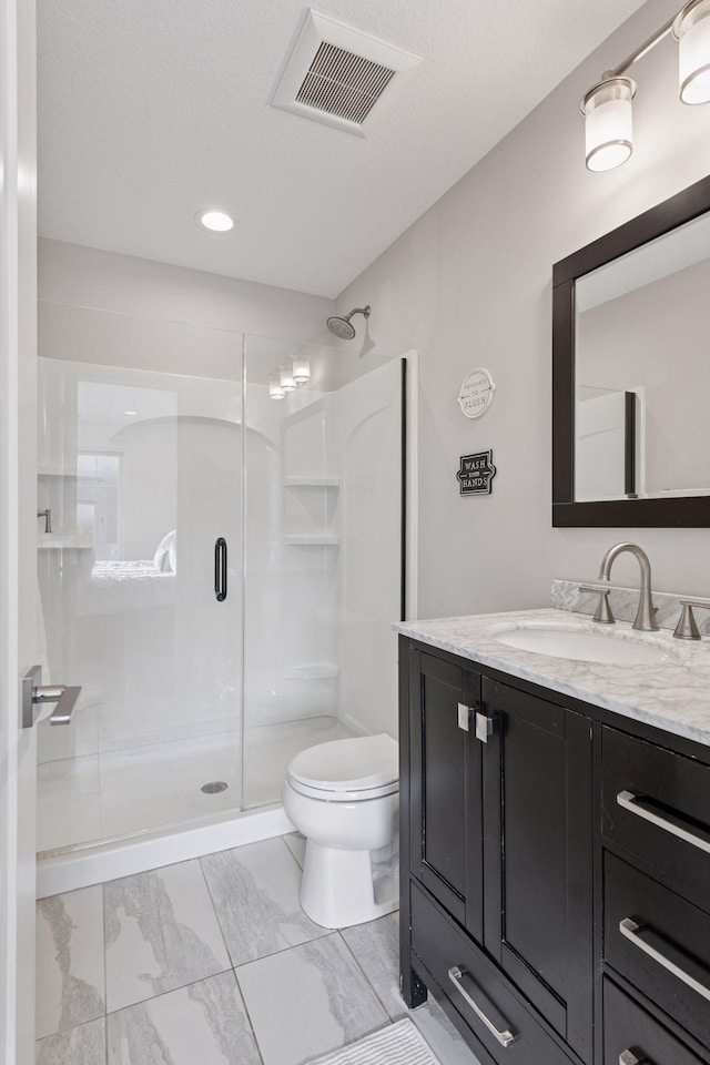 bathroom featuring visible vents, toilet, marble finish floor, a shower stall, and vanity