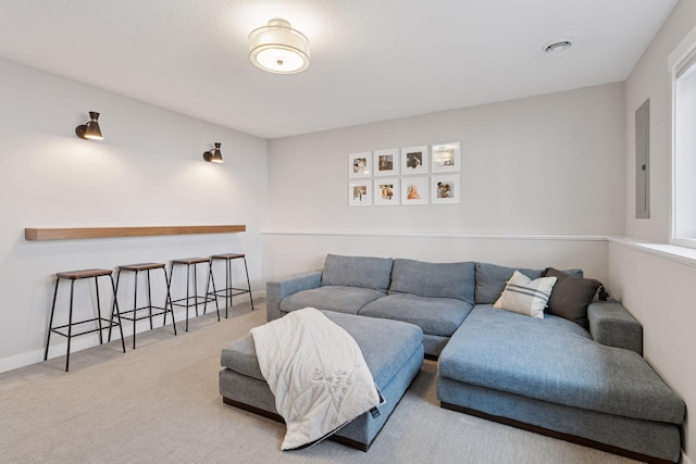 carpeted living room featuring electric panel and baseboards