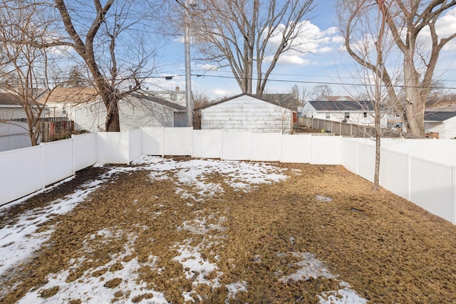 snowy yard with a residential view and a fenced backyard