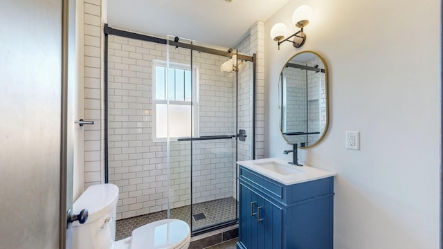 bathroom featuring vanity, toilet, and a shower stall