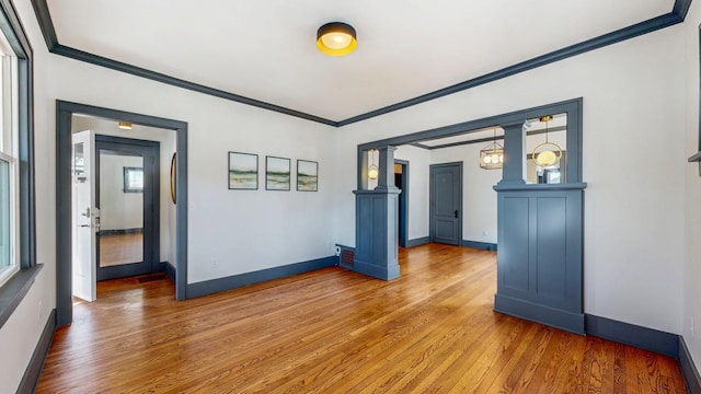 spare room with wood finished floors, baseboards, and ornamental molding