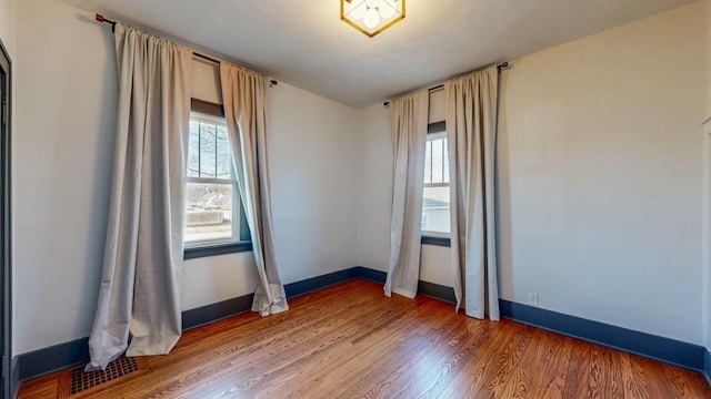 spare room featuring visible vents, baseboards, and light wood-style flooring