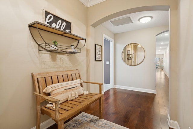 hall with baseboards, arched walkways, and dark wood-style floors