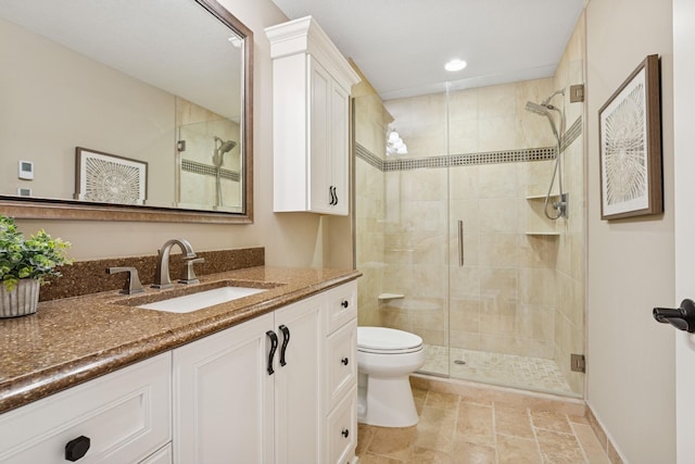 bathroom featuring a stall shower, toilet, and vanity