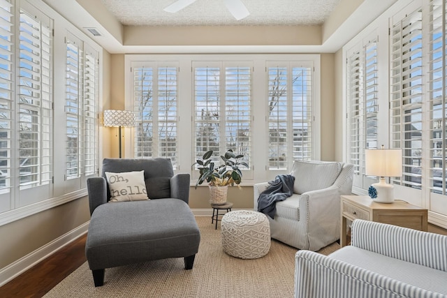 sitting room featuring a wealth of natural light, baseboards, and wood finished floors