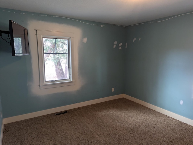 carpeted empty room with visible vents and baseboards