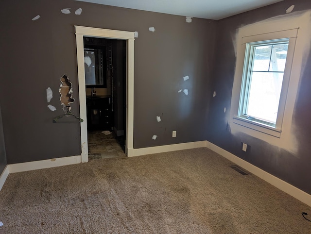 carpeted empty room featuring visible vents and baseboards