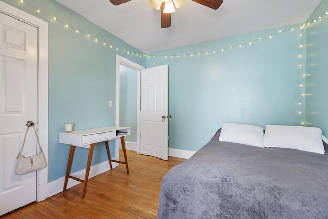 bedroom featuring a ceiling fan, baseboards, and hardwood / wood-style floors