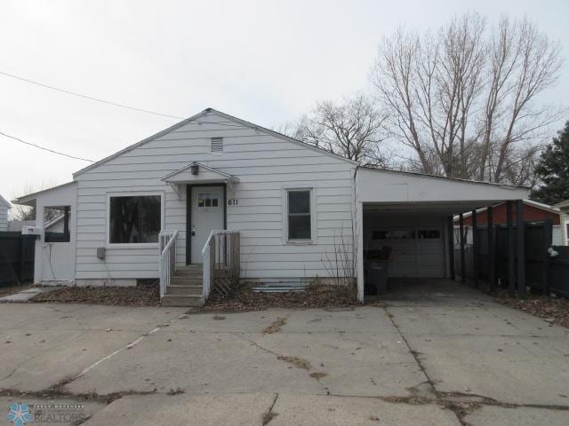 bungalow featuring an attached carport and driveway