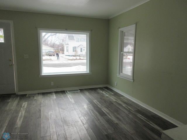 interior space featuring visible vents, dark wood-style floors, and baseboards