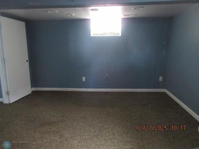 below grade area featuring baseboards and carpet floors