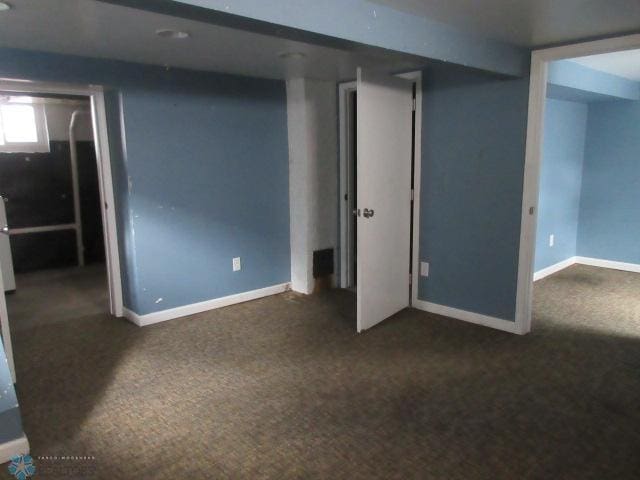 below grade area featuring carpet flooring and baseboards