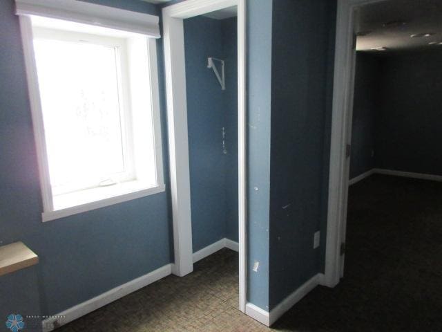 unfurnished bedroom featuring a closet and baseboards