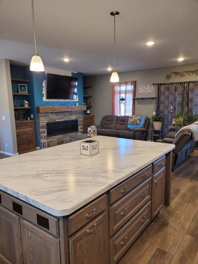 kitchen with a fireplace, open floor plan, dark wood finished floors, and light countertops