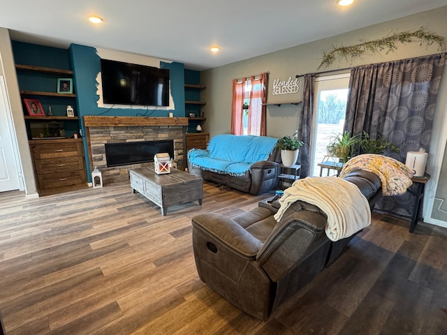 living area with recessed lighting, wood finished floors, and a fireplace