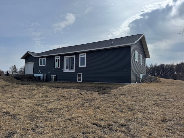 rear view of property featuring a yard and a garage