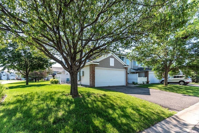 view of front of house with driveway, fence, a residential view, a front yard, and a garage