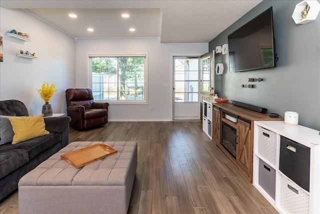 living area featuring recessed lighting, baseboards, and dark wood-style flooring