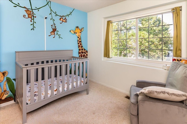 bedroom with baseboards, multiple windows, a crib, and carpet flooring